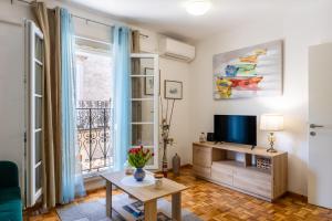 a living room with a tv and a table at Apartman Ana Lotre in Vela Luka
