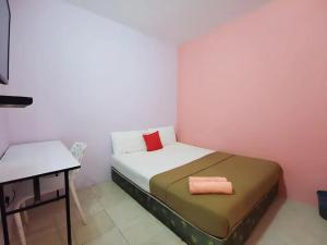 a small bedroom with a bed and a table at My Seven Day Inn in Masai