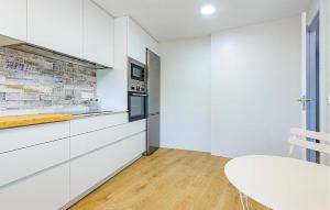 a kitchen with white cabinets and a white table at Apto Jérica in Jérica