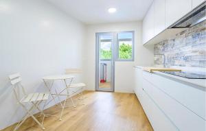 a kitchen with white cabinets and a table and chairs at Apto Jérica in Jérica