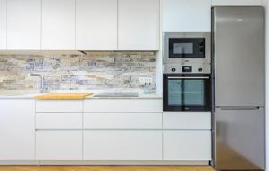 a white kitchen with a microwave and a refrigerator at Apto Jérica in Jérica