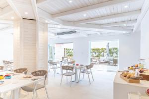 a dining room with white tables and chairs at Luma Relais de Charme in Santa Teresa Gallura