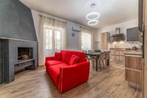 a living room with a red couch and a fireplace at Chateau De La Rose in Fonte Nuova