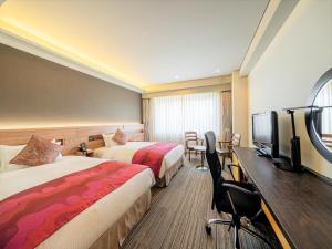 a hotel room with two beds and a flat screen tv at KKR Hotel Hakata in Fukuoka