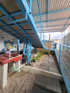 a building with blue beams and a red sink at Hostel Samara in Sámara