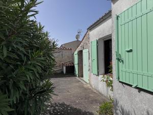an alley with green shutters on two buildings at Maisonnette au centre de St Pierre in Saint-Pierre-dʼOléron +1 photo