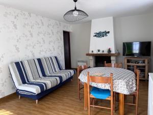 a living room with a couch and a table at Maisonnette au centre de St Pierre in Saint-Pierre-dʼOléron