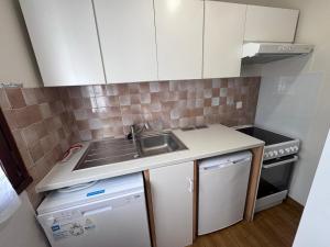 a small kitchen with a sink and a stove at Maisonnette au centre de St Pierre in Saint-Pierre-dʼOléron