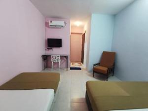 a room with two beds and a desk and a television at My Seven Day Inn in Masai +19 photos