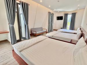 a hotel room with two beds and a tv at Khách sạn Vân Nhi 2 in Bạc Liêu +28 photos
