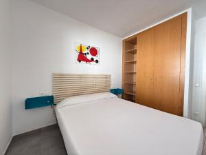 a bedroom with a white bed and a wooden cabinet at Agi Las Acacias in Roses +32 photos