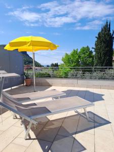 a yellow umbrella and a bench on a roof at B&B Locanda Al Pontesel in Garda