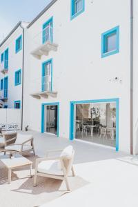 a white building with chairs and tables in front of it at Luma Relais de Charme in Santa Teresa Gallura