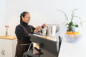 a woman is standing in front of a machine at Luma Relais de Charme in Santa Teresa Gallura