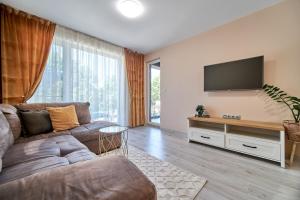 a living room with a couch and a flat screen tv at 100m from the BEACH! ALDEA complex with pool in Kavarna