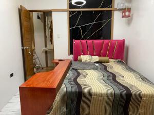 a bedroom with a bed with a pink head board at Casa Sandrine Resort in Malolos