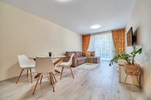 a living room with a table and chairs and a couch at 100m from the BEACH! ALDEA complex with pool in Kavarna