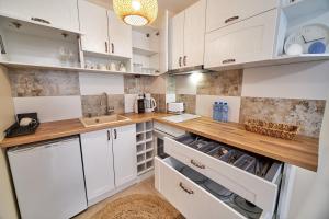 a kitchen with white cabinets and a wooden counter top at 100m from the BEACH! ALDEA complex with pool in Kavarna +9 photos