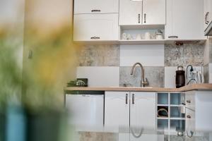 a kitchen with white cabinets and a sink at 100m from the BEACH! ALDEA complex with pool in Kavarna