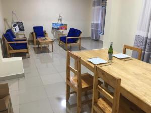 a room with chairs and a table and a bottle of wine at Bella Famiglia in Ruhengeri +5 photos