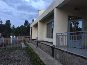 a house with a fence next to a door at Bella Famiglia in Ruhengeri