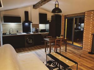 a living room with a table and a kitchen at Briques & Bulles in Montauban