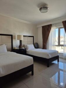 a hotel room with two beds and a window at Le Vendome Hotel in Amman +31 photos