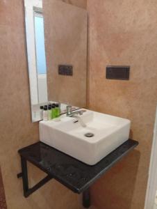 a bathroom with a white sink and a mirror at Holiday Apartment Ragama in Kurukulawa