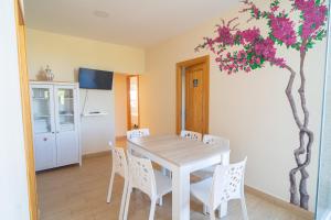 a kitchen and dining room with a table and a tree at Piso La Buganvilla in Bailén