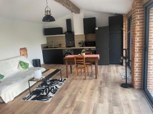 a living room with a table and a kitchen at Briques & Bulles in Montauban +8 photos