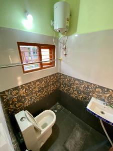 a bathroom with a toilet and a sink at Coorg Nature vista in Kushālnagar