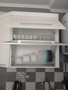 a white refrigerator with plates and dishes in it at Gray in Ternopil +14 photos