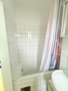 a white bathroom with a tub and a sink at Beenie 16 in Linz
