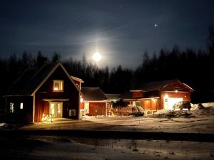 a house at night with the moon in the sky at Hus Orsa in Orsa