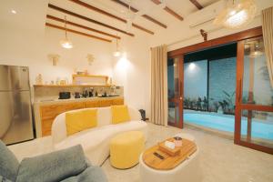 a living room with a couch and a table at Gili Nomade Villas in Gili Trawangan