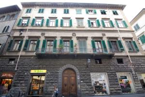 een groot stenen gebouw met groene luiken en een houten deur bij Proconsolo Superior Apartment in Florence
