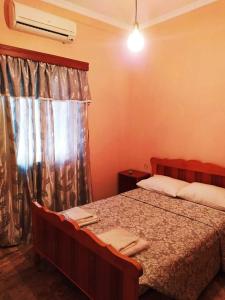 ein Schlafzimmer mit einem Bett und einem Fenster in der Unterkunft Eleni's house in Masouri