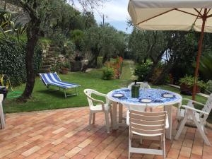 a table with chairs and an umbrella on a patio at la Baracca in Genoa