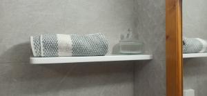 ein Regal im Badezimmer mit Handtüchern darauf in der Unterkunft Eleni's house in Masouri