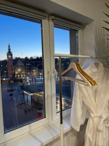 a dress in a window with a view of a clock tower at Million Gold Gdańsk in Gdańsk