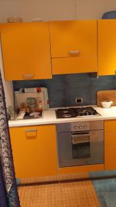 a kitchen with orange cabinets and a stove at la Baracca in Genoa
