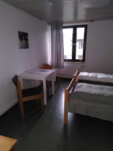 ein Schlafzimmer mit einem Tisch, einem Bett, einem Tisch und Stühlen in der Unterkunft Zimmer 13 in Gomadingen