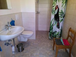 ein Badezimmer mit Waschbecken, Toilette und einem Duschvorhang mit Pinguinmotiv in der Unterkunft Zimmer 13 in Gomadingen