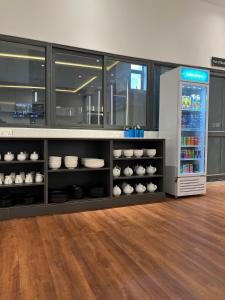 a kitchen with a shelf with dishes and a refrigerator at D'Crown Place in Abuja