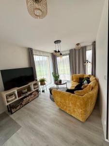 a living room with a couch and a flat screen tv at Modern House with Private Pool & Terrace in Červená Třemešná