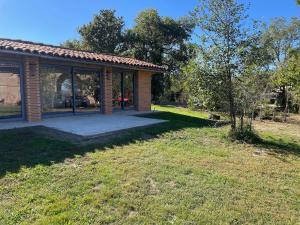 a house with a patio and a tree in the yard at Briques & Bulles in Montauban