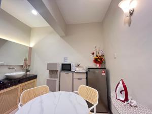 a small kitchen with a table and a sink at Asimmy Hotel in Kampong Gurun