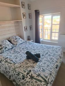 a bedroom with a bed with a blue and white comforter at Appartement cosy calme centre Issoire Belle vue sur le massif du Sancy et le Livradois-Forez WiFi in Issoire