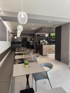 ein Restaurant mit Tischen und Stühlen und einer Bar in der Unterkunft Hotel Costa Azzurra in Grado