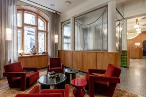 a waiting room with red chairs and a table at Carillon Aparthotel - Keystone Collection, opened December 2025 in Riga